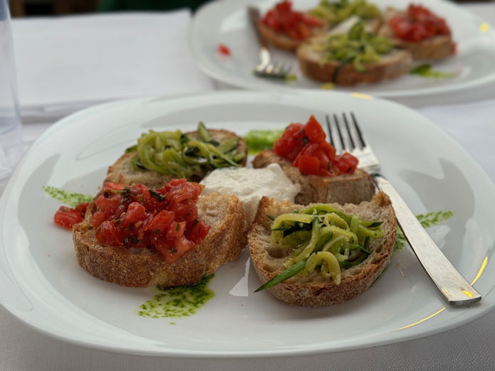 bruschetta al pomodoro, zucchine e burrata con perlage di pesto