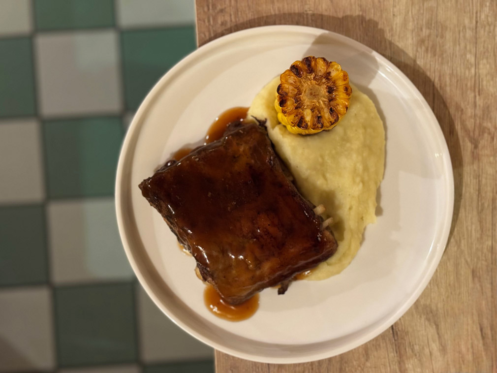 Costine di maiale con purè e rafano, pannocchia arrosto © Fermata Spettacolo