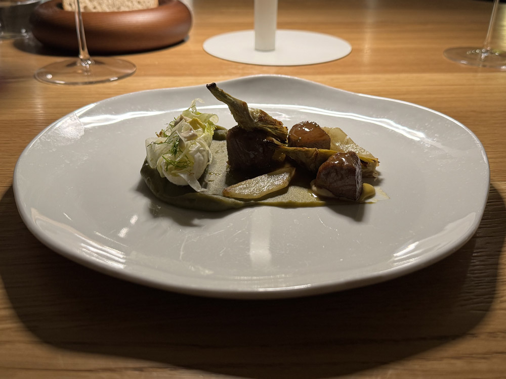 Scamona di agnello glassata con fondo bruno, crema di carciofi, carciofi e finocchio arrostiti, indivia ripiena di finocchio conditi con senape al miele e maionese ai semi di sesamo © Fermata Spettacolo